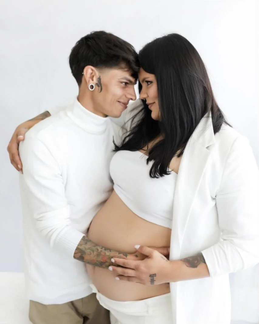 Casal abraçado de branco em ensaio gestante